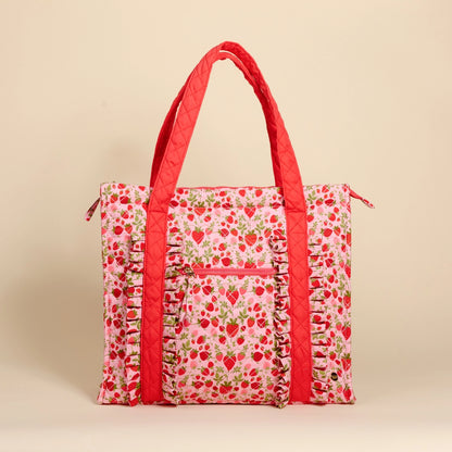 strawberry patterned tote bag with red accents on a beige background