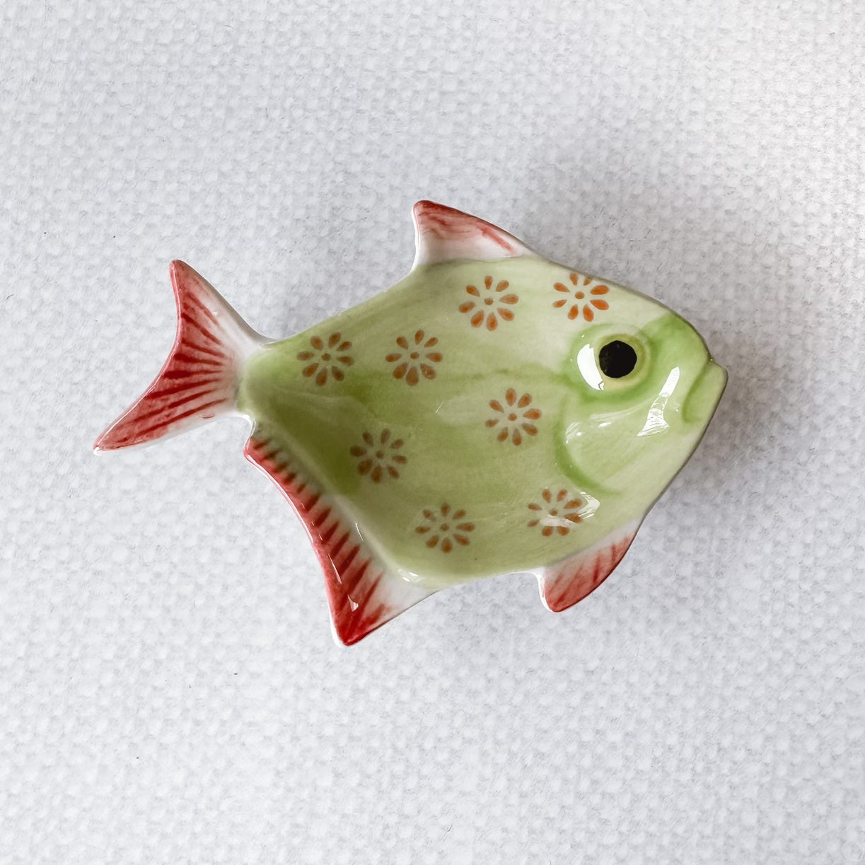 green fish with red flowers and red fins.