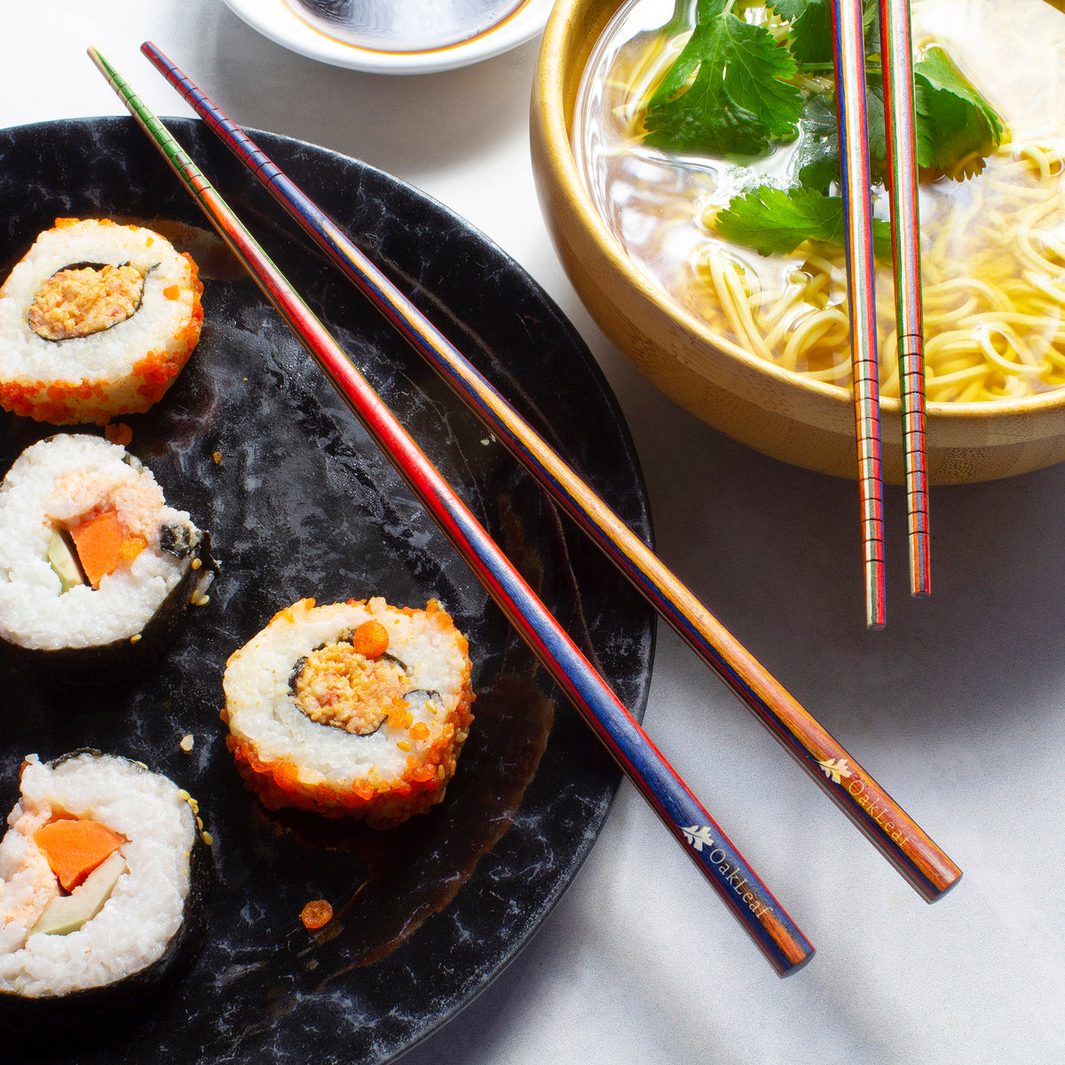 2 sets of Marrakesh Chopsticks resting on a the edge of plated food