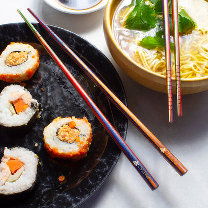 2 sets of Marrakesh Chopsticks resting on a the edge of plated food