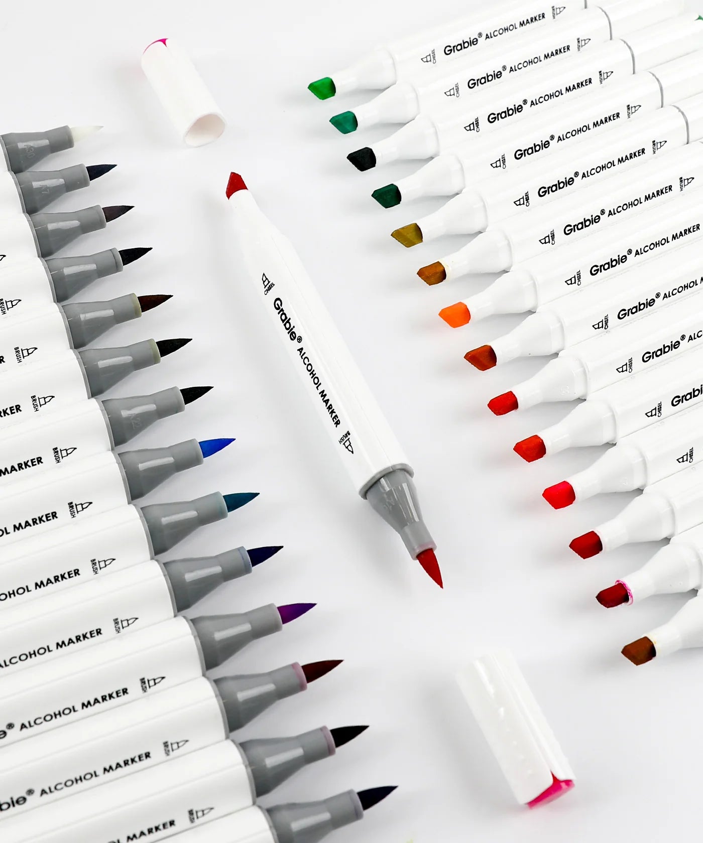 Set of grabie alcohol markers with caps off showing tips on a white background