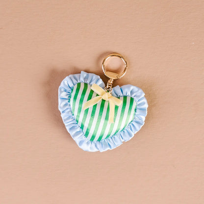 cool crush Heart-shaped bag charm with green and white striped design on a beige background