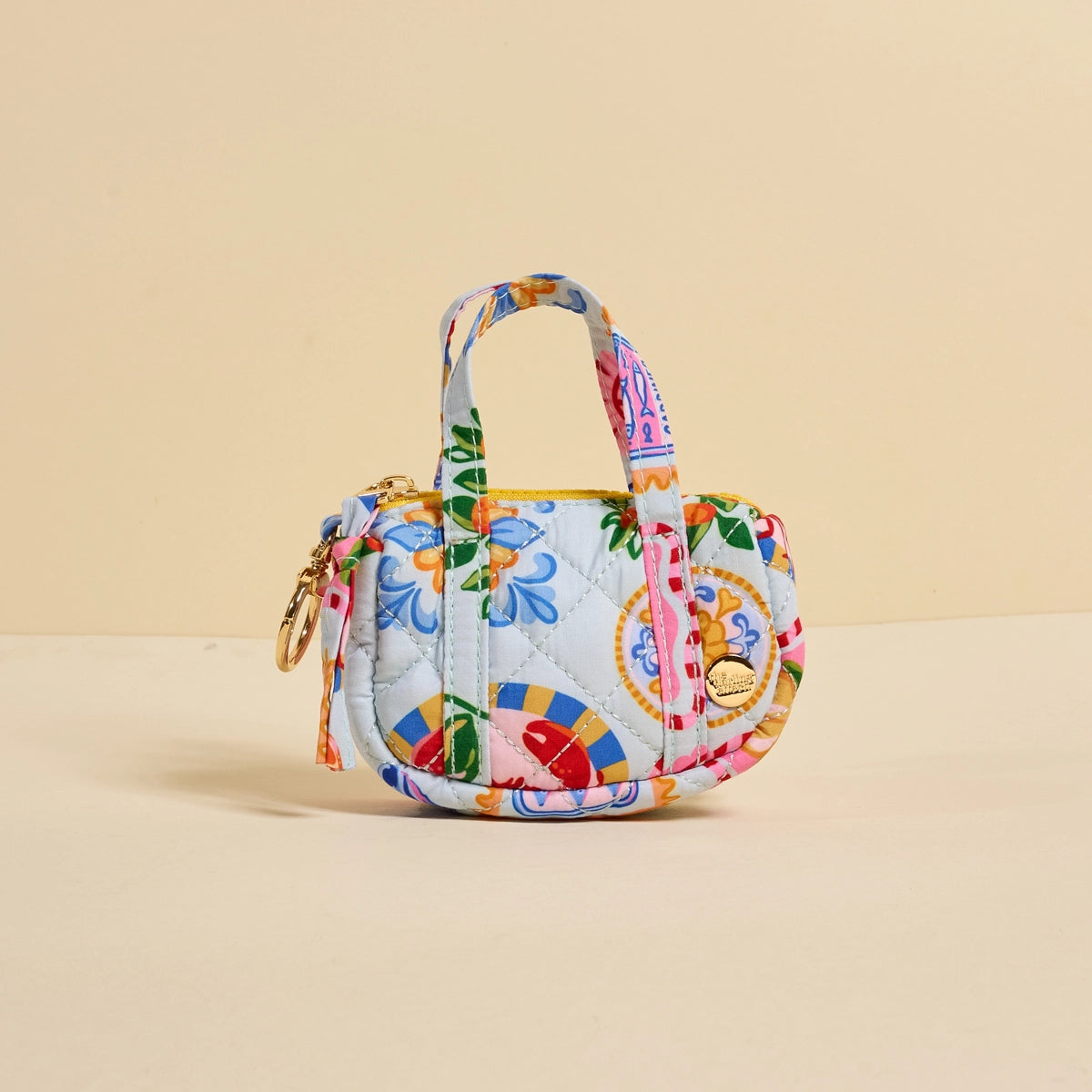 Colorful quilted tiny handbag with floral pattern on a beige background
