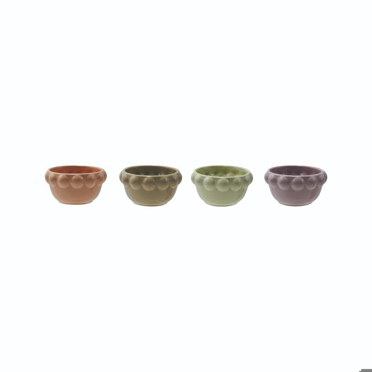 ceramic little bowls with bubble rims in a row on a white background