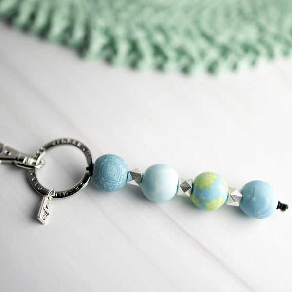 keychain with 4 blue patterned beads, silver spacer beads, and silver keyring.