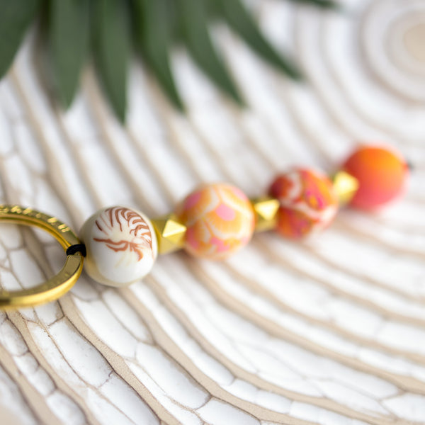 keycahine with 4 pink and orange patterned beads, gold spacer beads, and gold keyring.