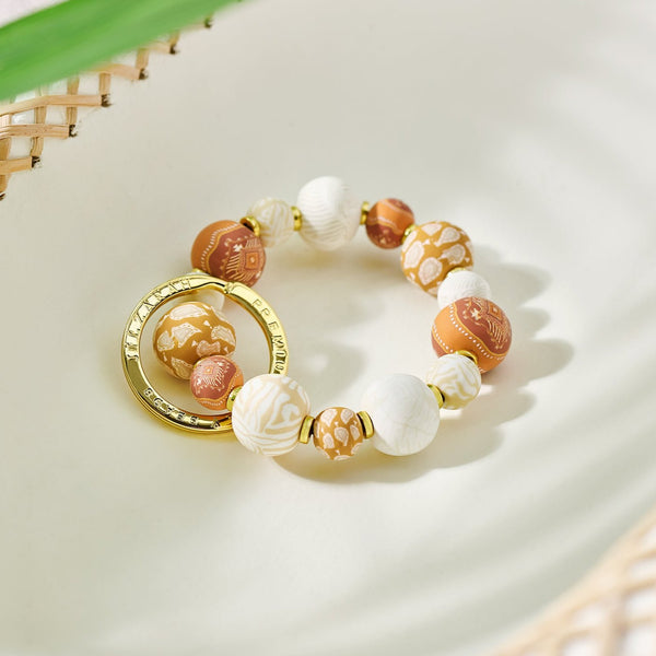 Sahara Small Bead Keychain laying on a dish with leaves in the background