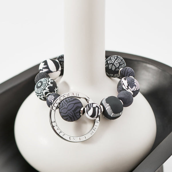 Noir Small Bead Keychain draped over the neck of a vase