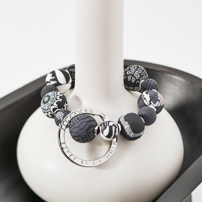 Noir Small Bead Keychain draped over the neck of a vase