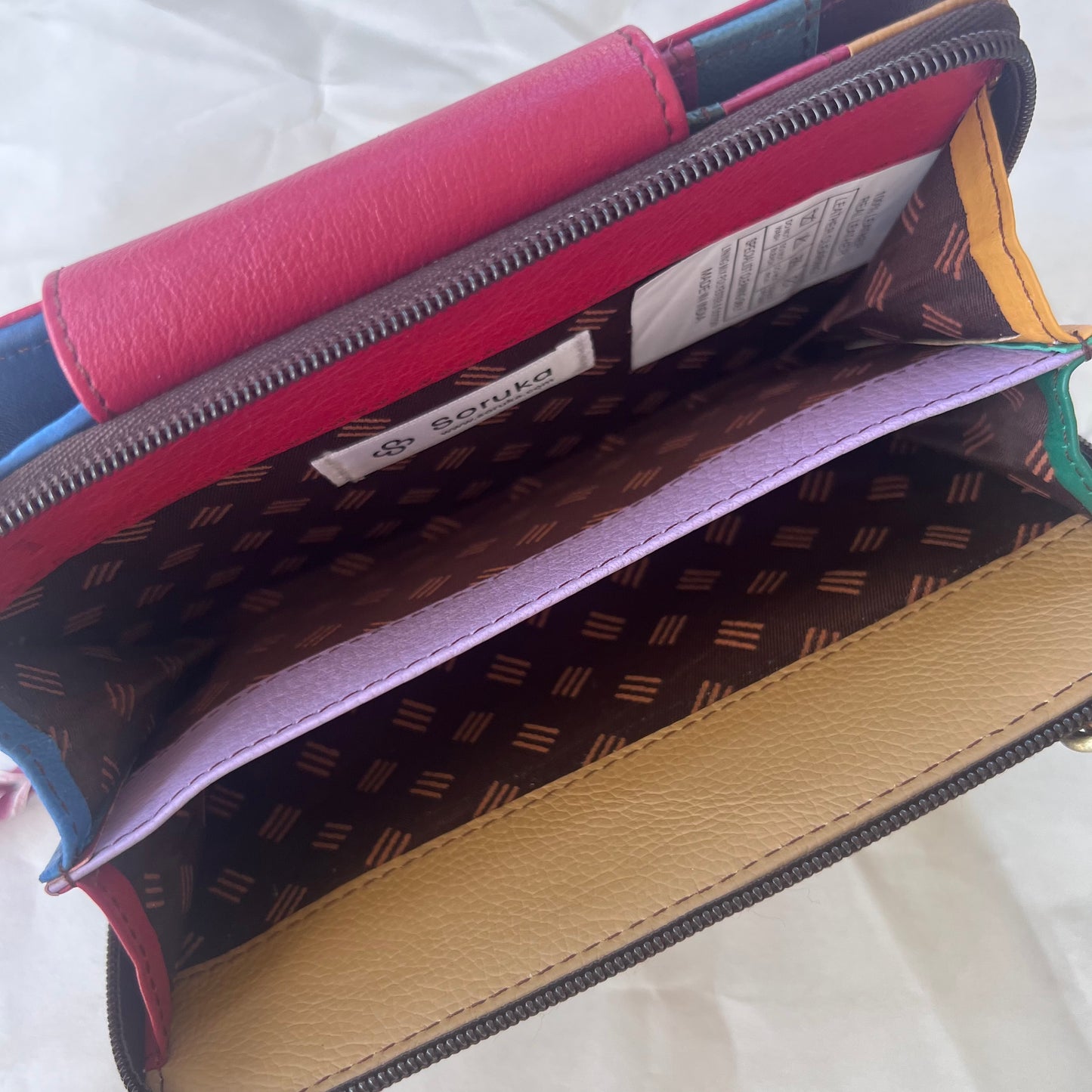 view of interior zippered compartment of red Beatrice Clutch