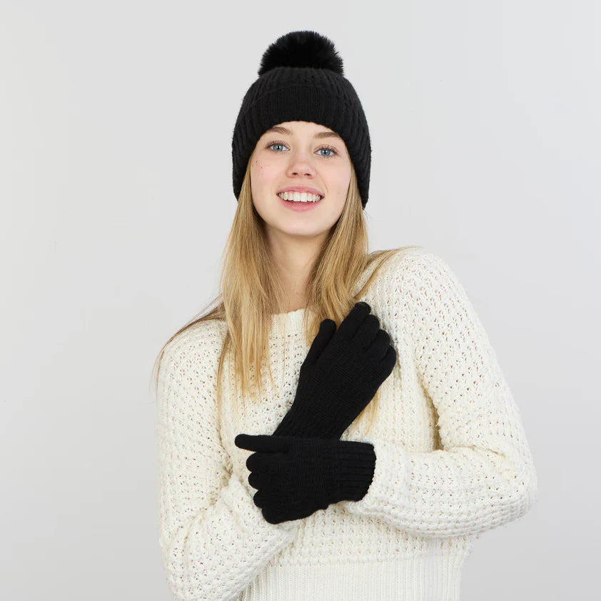 smiling Person wearing a white sweater and black gloves