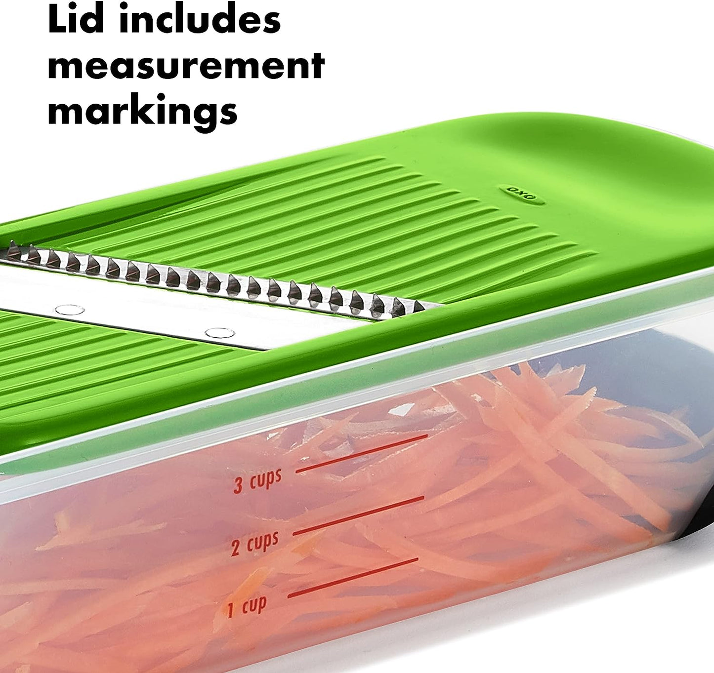 close-up of julienne slicer on the food holder that is filled with juilenned carrots and text "lid includes measurement markings" in the top corner.
