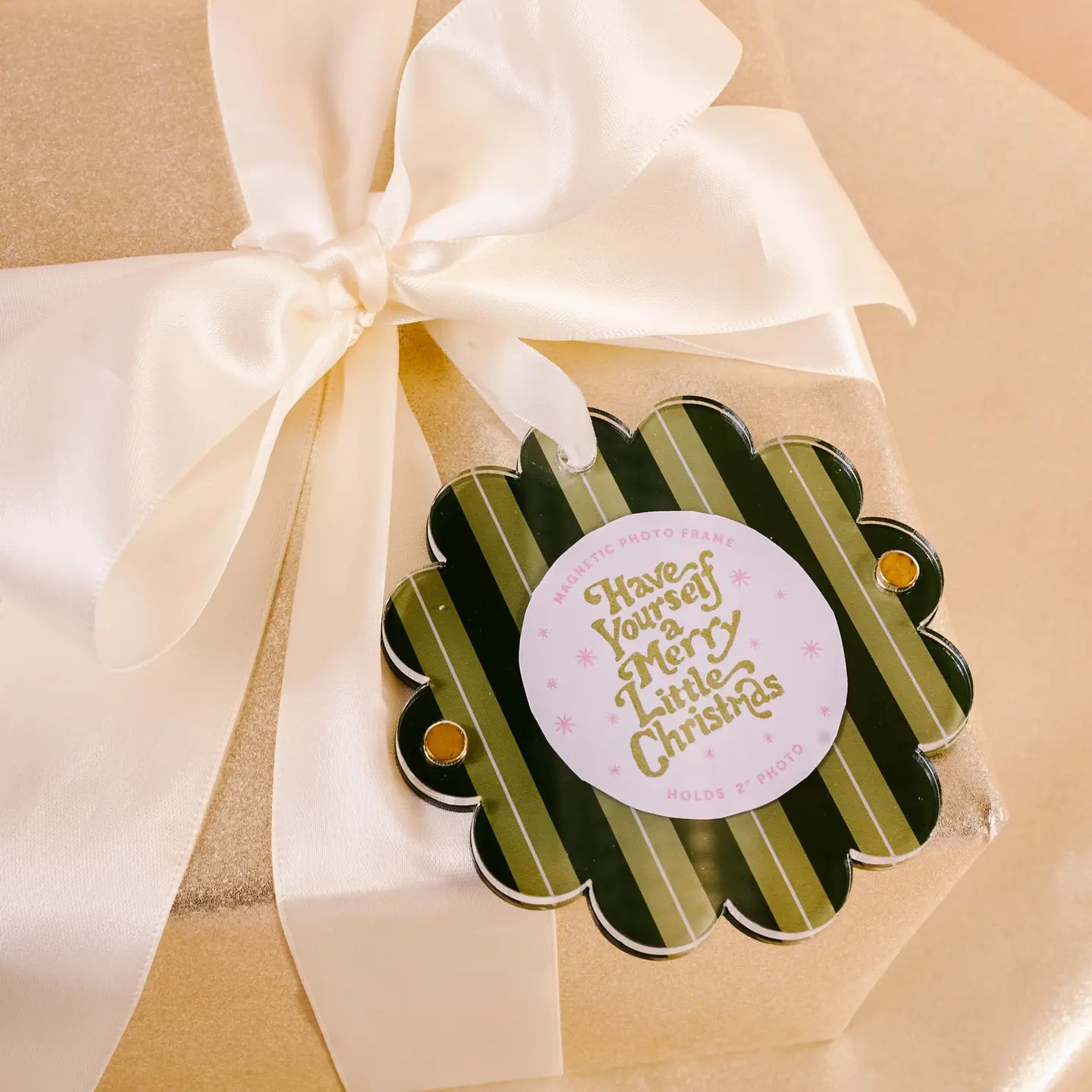 green striped small acrylic frame with scalloped edge tied in an ivory bow of a wrapped present