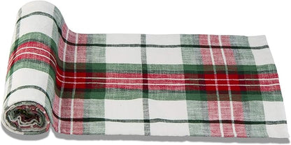 festive plaid table runner partially rolled up and shown on a white background.