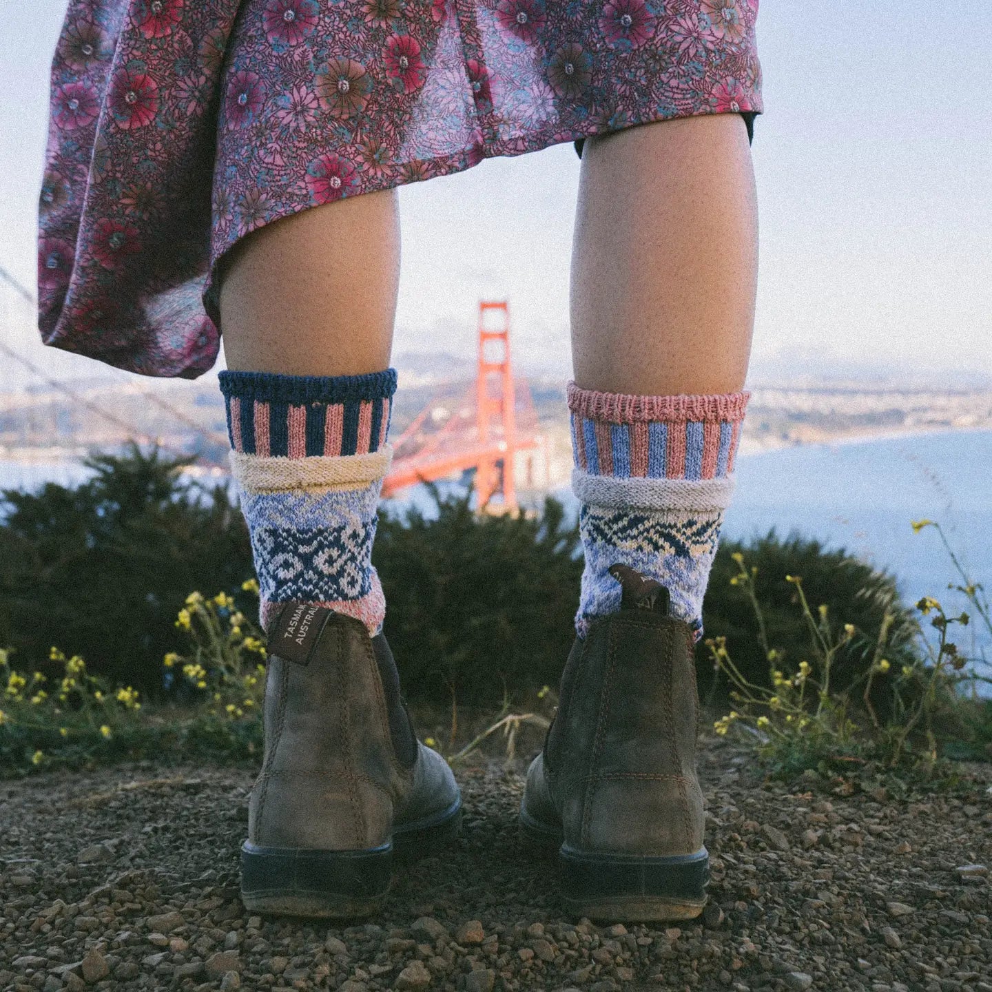 close-up of person wearing boots, a floral skirt, and Mirage Crew Socks standing on a hilltop overlooking the golden gate bridge