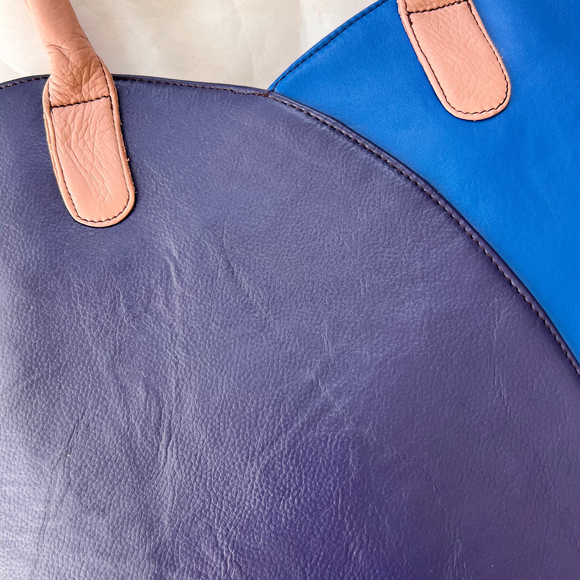 close-up of other side of valeria tote that is half bright blue and half navy blue.