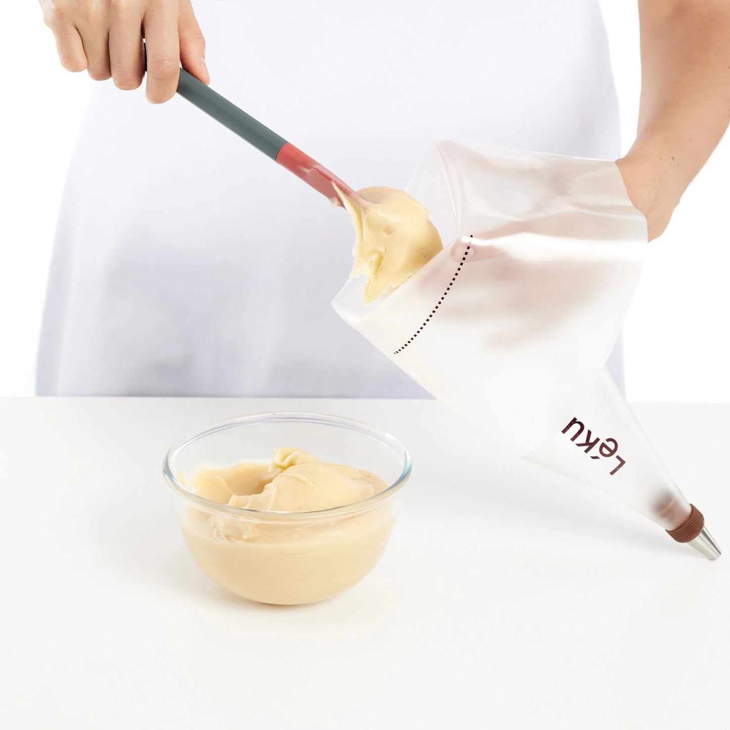 person filling icing bag with icing