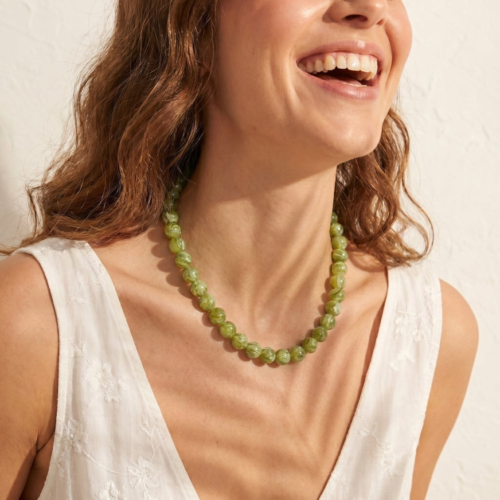 a person wearing the chunky green beaded necklace