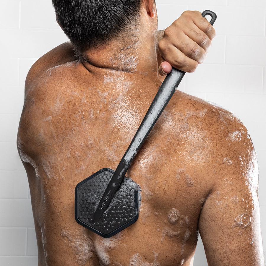 person scrubbing their back with silicone scrubber.