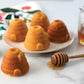 beehive cakelets baked and displayed on a small plate next to a honey wand and napkin