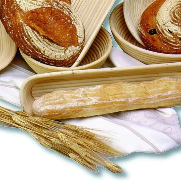 assorted sizes and shapes of brotforms arranged with breads and wheat.