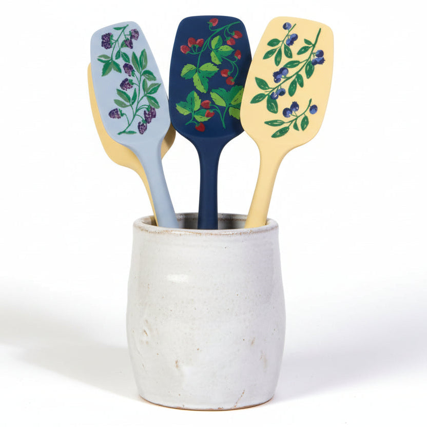 silicone spoonulas with berry designs in a white crock on a white background