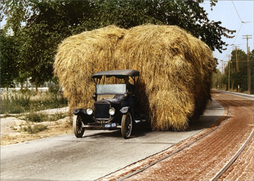front of card is an old fashioned truck hauling two giant hay bails