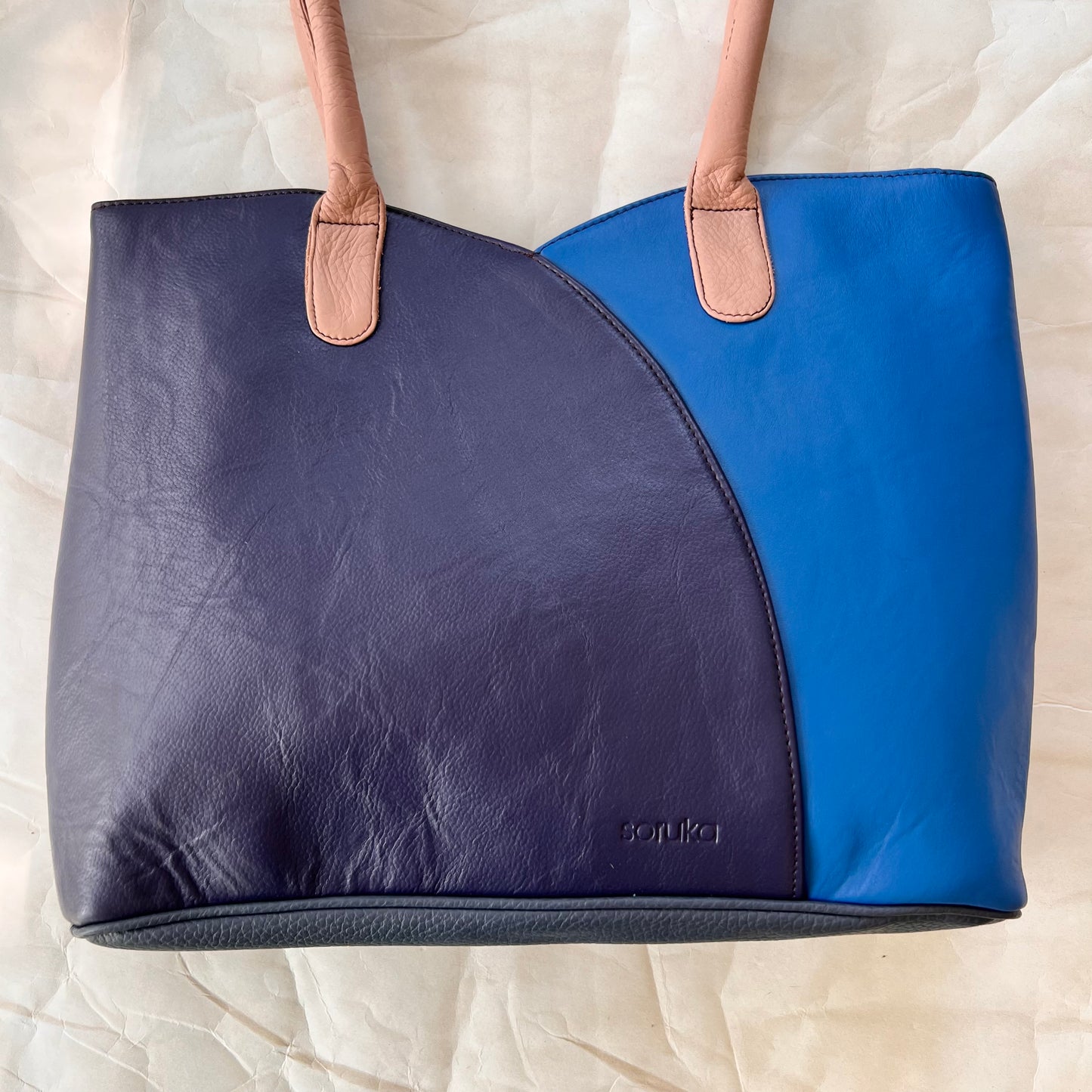 other side of valeria tote that is half bright blue and half navy blue.