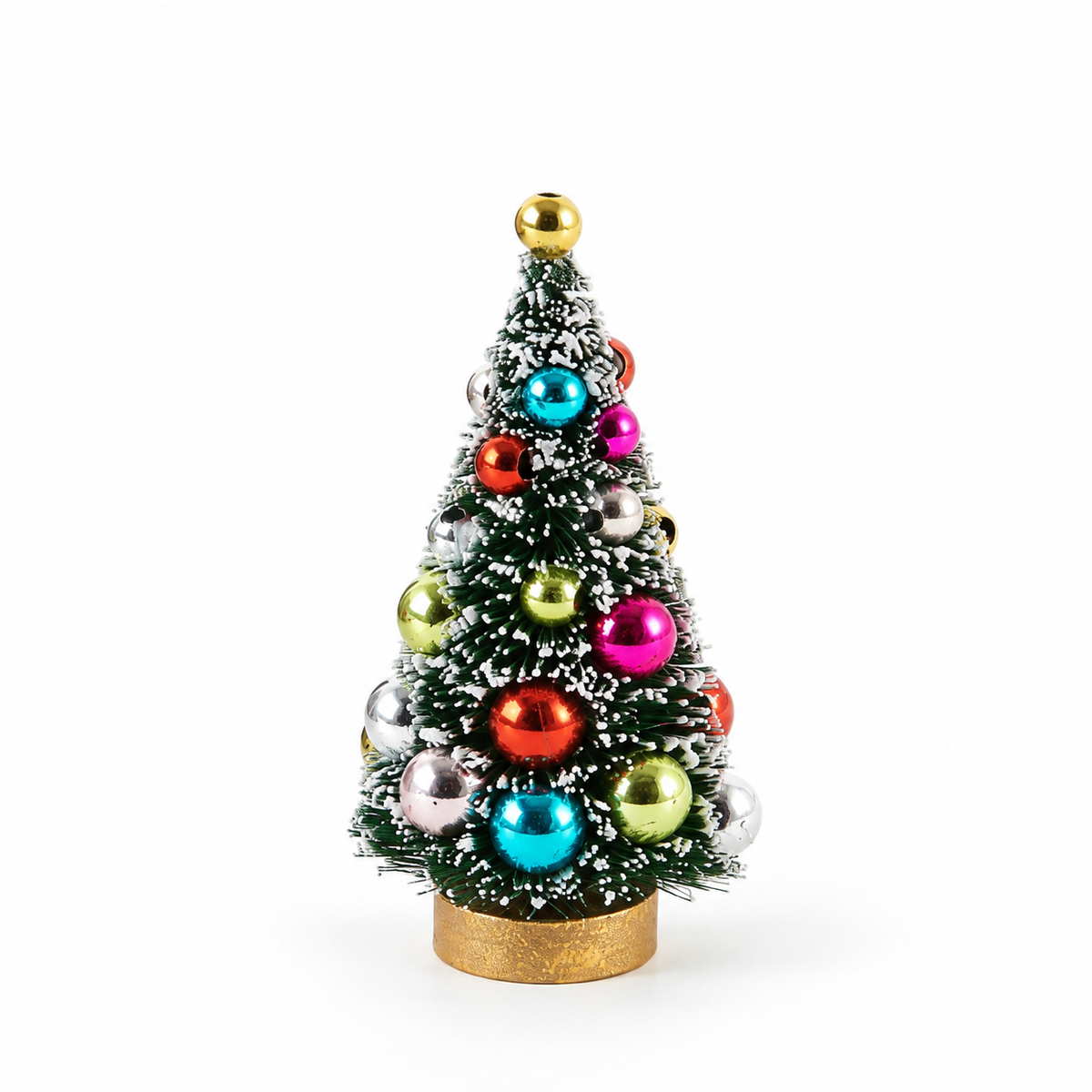 A small artificial Christmas tree with white faux snow, decorated with shiny multicolor ornaments in red, blue, pink, green, silver, and gold, topped with a gold ball and standing on a gold base against a white background.