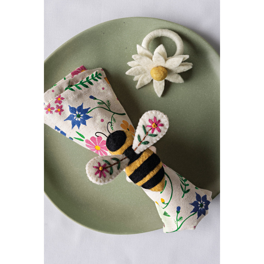 bee garden napkin on a green plate with bee napkin ring on it