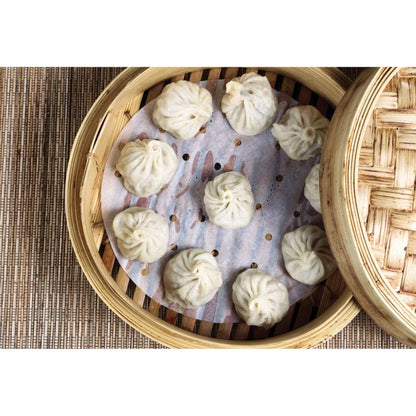 Steamed buns in a bamboo steamer on a woven mat