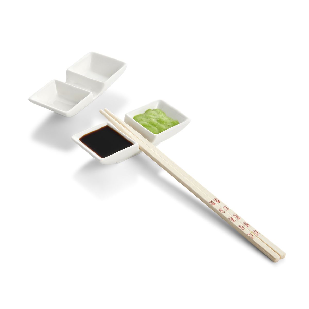 A two-section sauce dish with chopstick rest, one dish is filled with dips