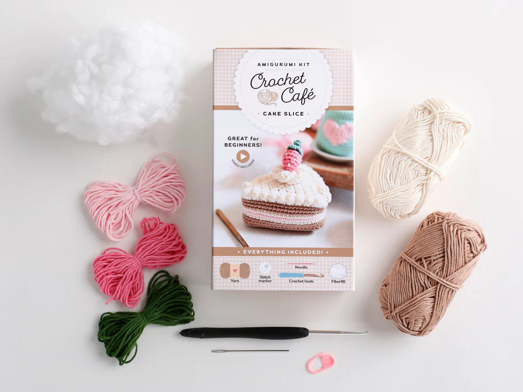 Crochet kit parts for a crocheted slice of cake on a white background. 