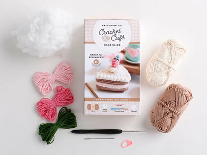 Crochet kit parts for a crocheted slice of cake on a white background. 