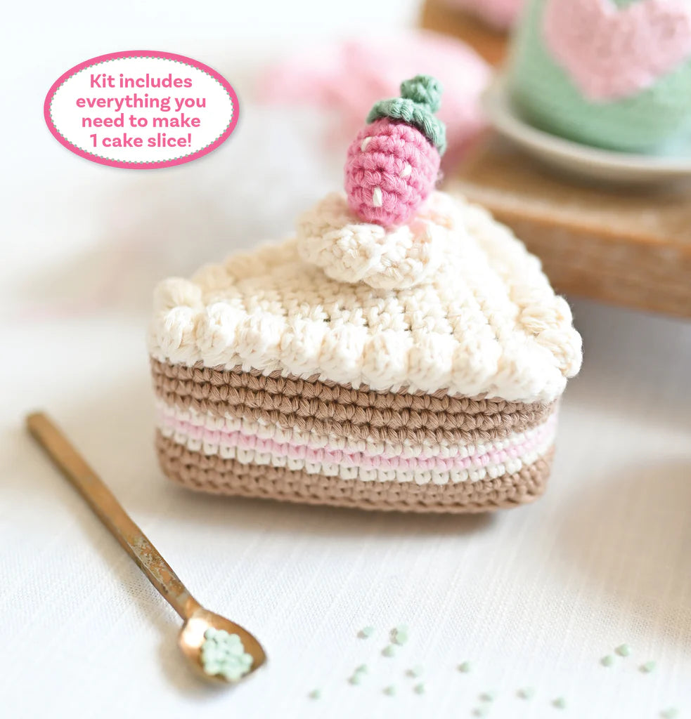 Crocheted slice of chocolate cake with strawberry on top.