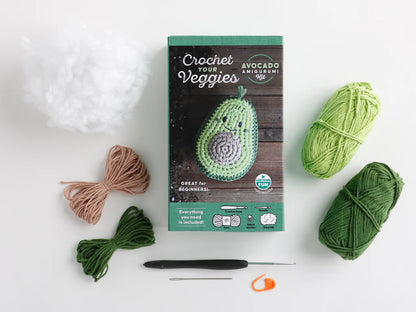 Crochet avocado amigurumi kit with yarn and tools on a white background