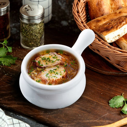 french onion soup bowl filled with french onion soup set on a table with a basket of bread