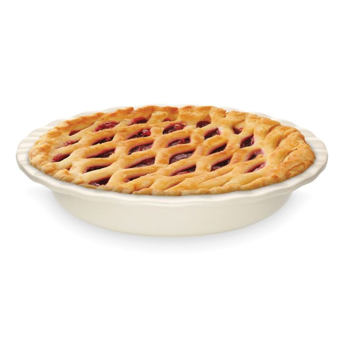 Pie with a lattice crust in a white pie dish against a white background