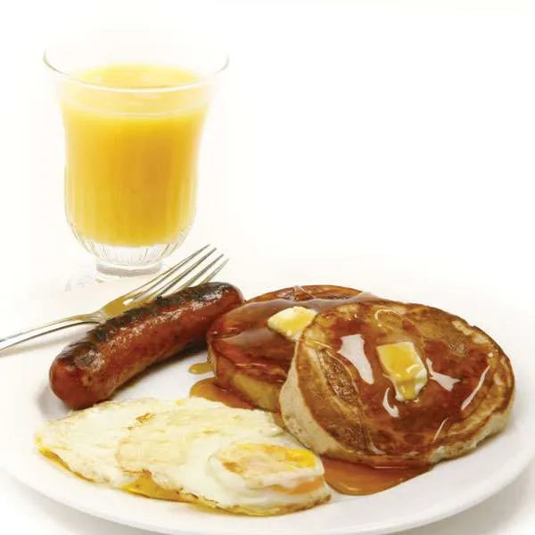 plate of breakfast foods with pancakes and eggs made in Stainless Steel Egg or Pancake Rings and a glass of juice in the background
