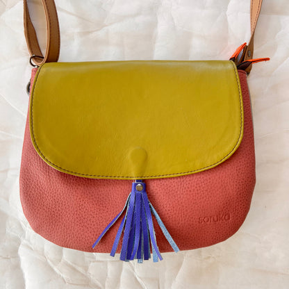 lola bag with lime green flap with royal tassel over a dusty rose body.