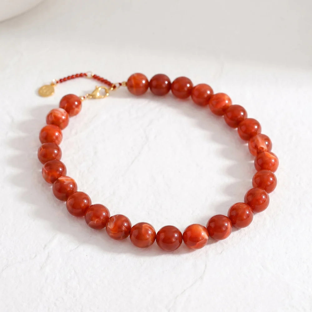 red chunky beaded necklace on a textured background