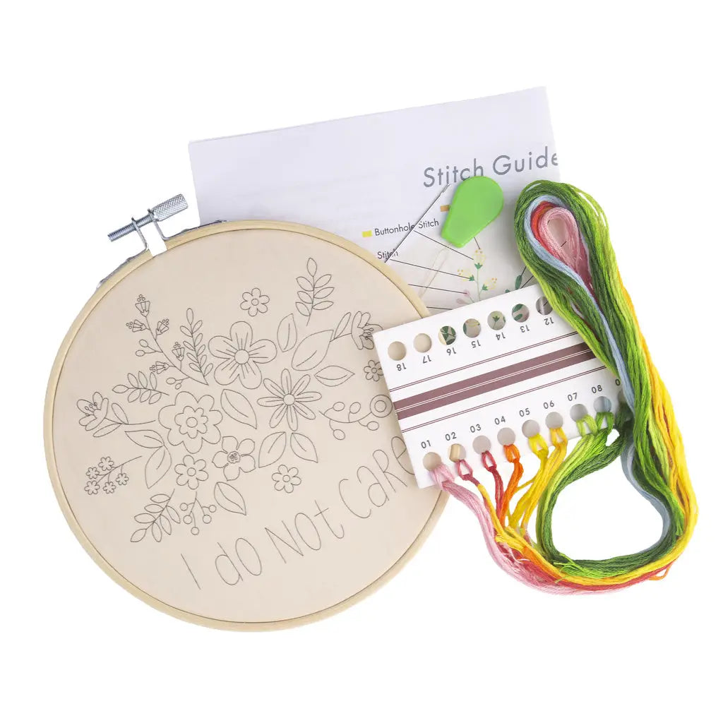 Embroidery hoop with floral design, thread, and stitch guide on a white background