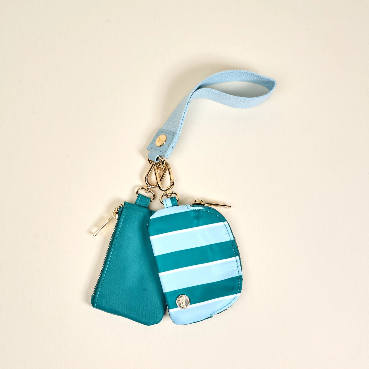 Teal and light blue striped pouch with matching wristlet on a beige background