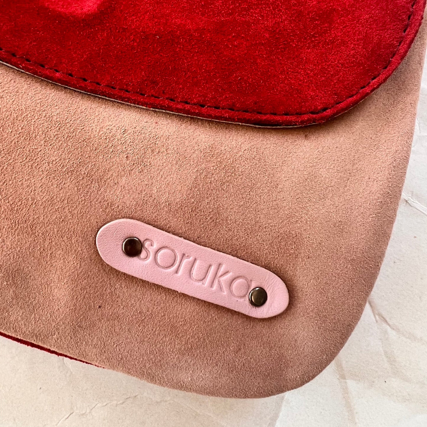 close-up of corner of purse showing "soruka" logo.