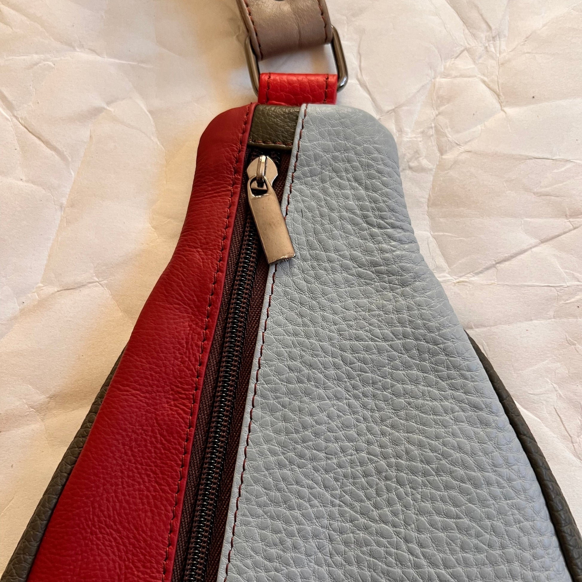 close-up of top of roxi sling bag showing zipper pull.