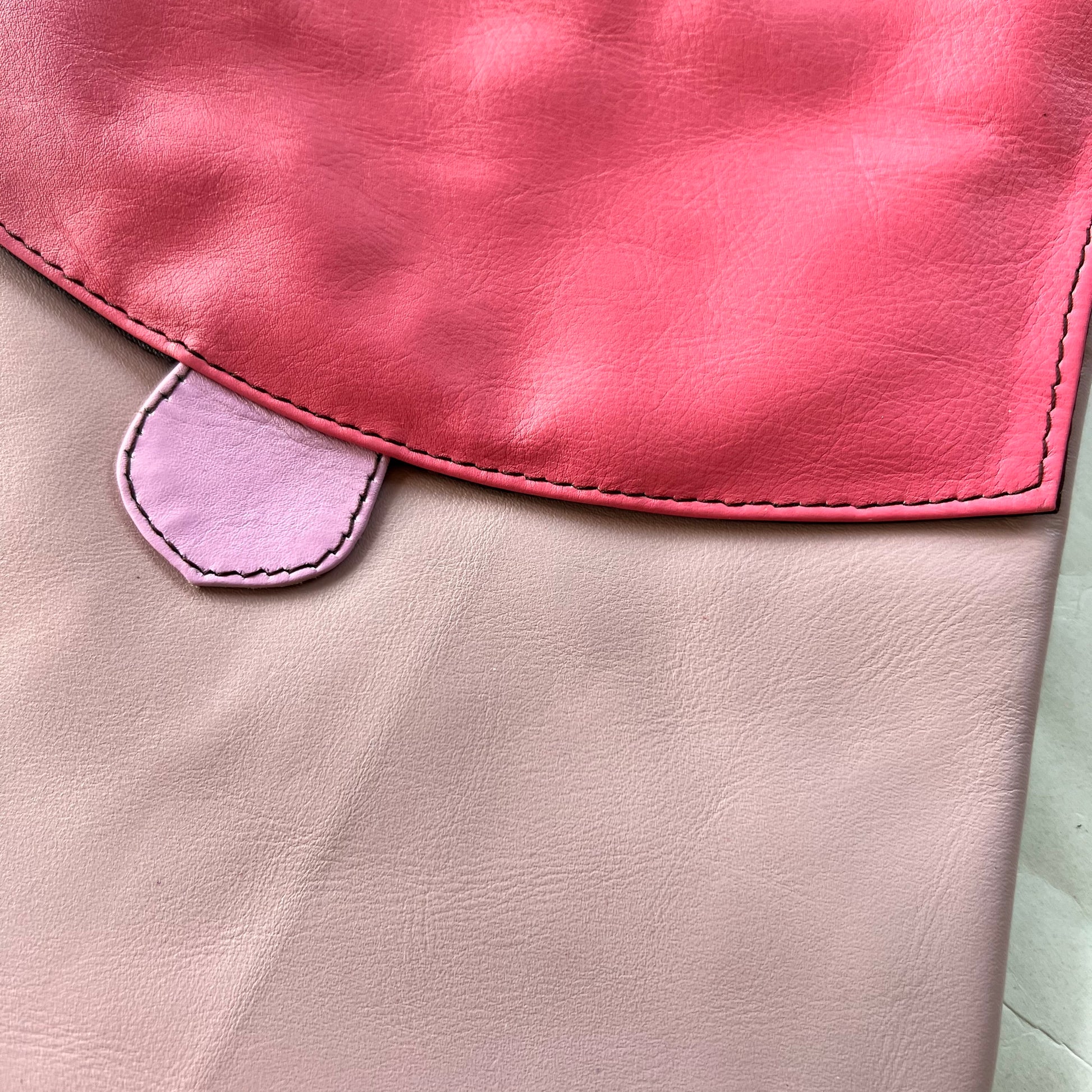 close-up of greta bag with pink flap over lilac body.