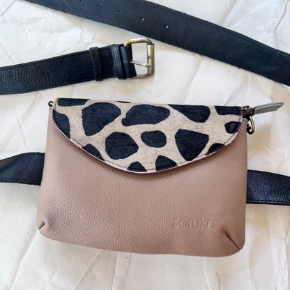 small taupe carol bag with black and white animal print flap and grey belt.