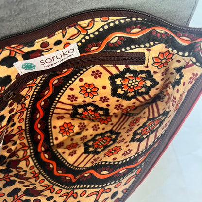 interior view of saddle bag showing inner zip pocket and patterned lining.