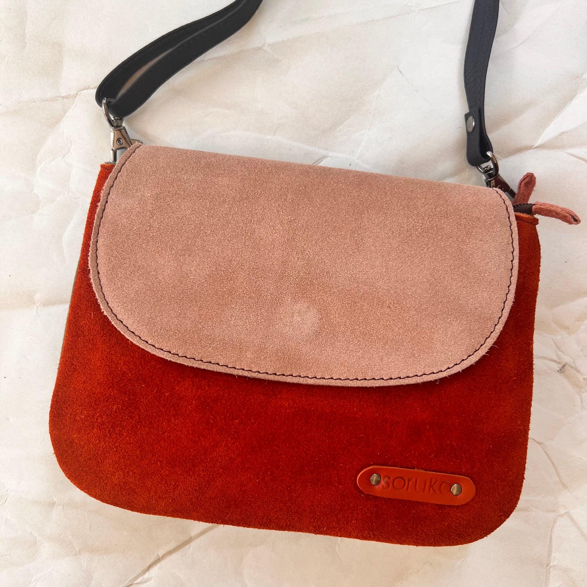 leo purse with orange body and blush flap.