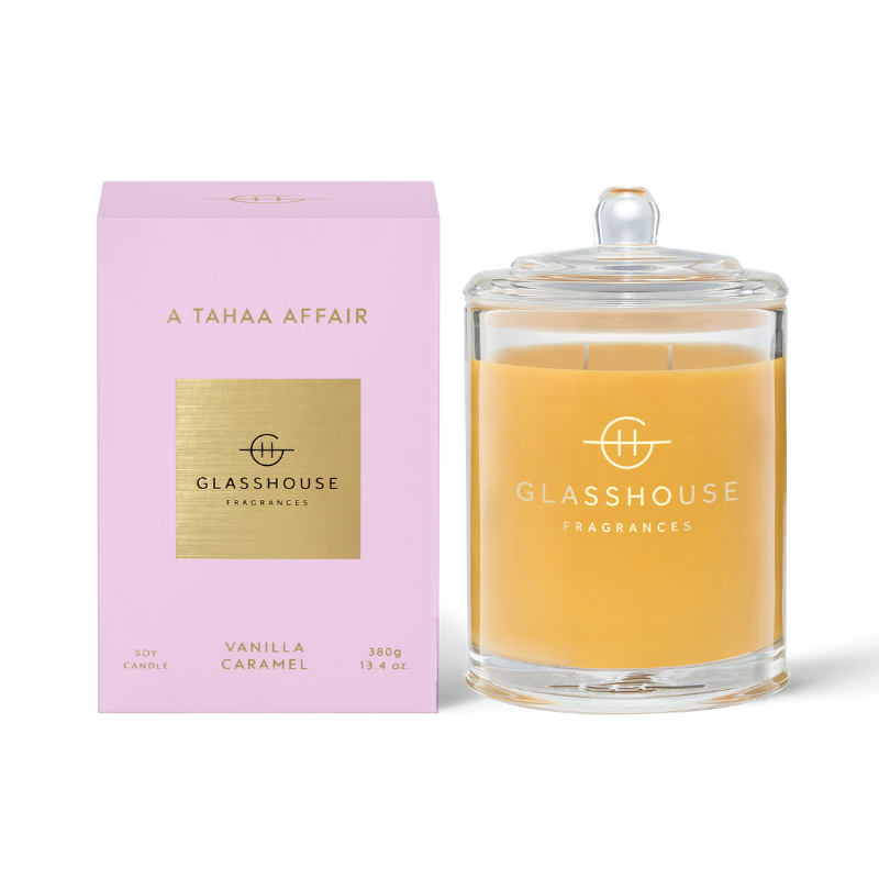 A Tahaa Affair Triple Scented Candle jar displayed next to the light pink box against a white background